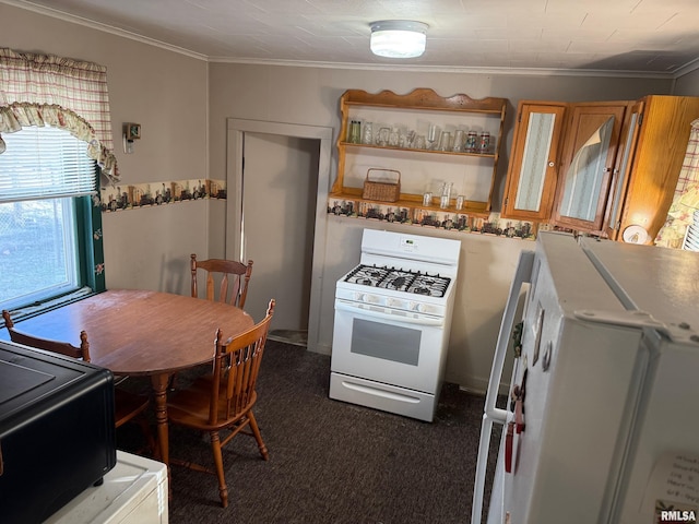 kitchen featuring white gas range, ornamental molding, fridge, and dark colored carpet