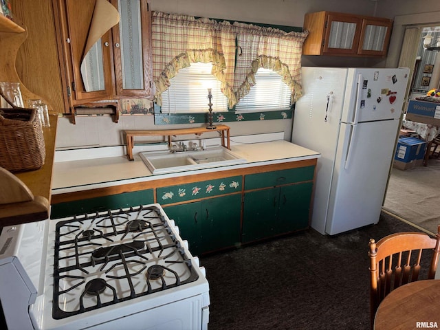 kitchen with dark carpet, sink, and white appliances