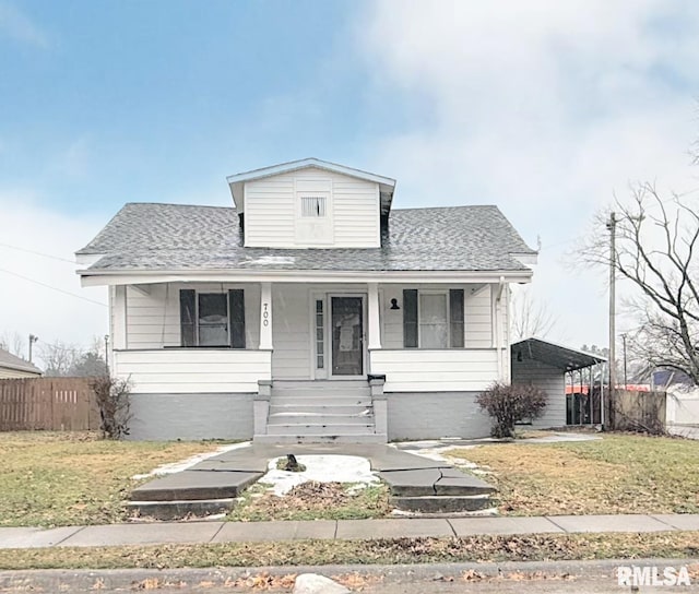 bungalow with a carport, a front yard, and covered porch