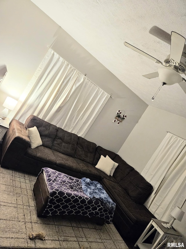 living room featuring ceiling fan and a textured ceiling