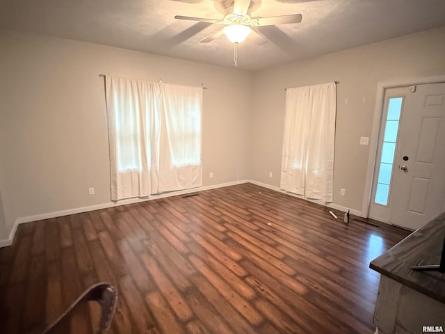 interior space with ceiling fan and dark hardwood / wood-style flooring