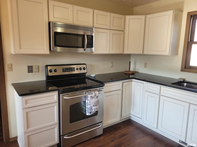 kitchen featuring sink, stainless steel appliances, dark hardwood / wood-style floors, and white cabinets