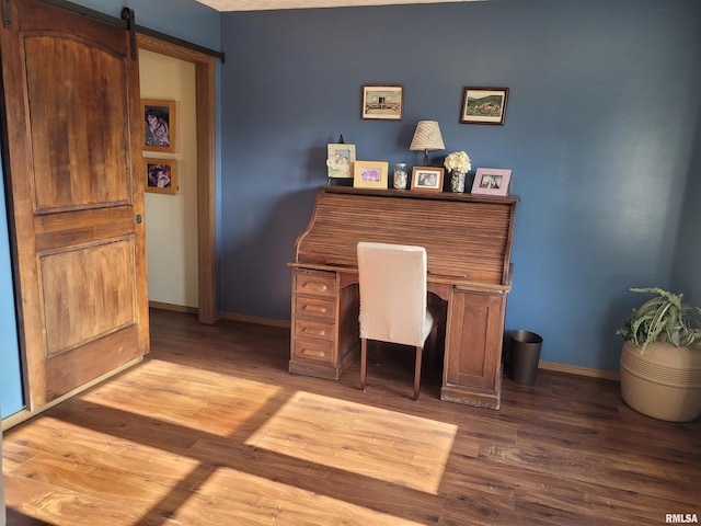 office space with wood-type flooring and a barn door