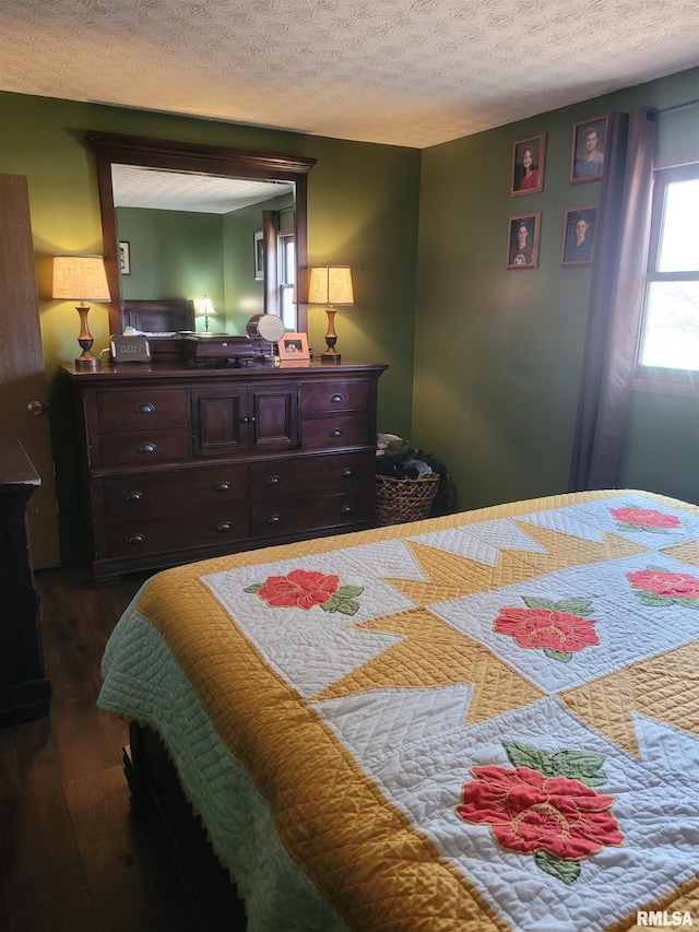 bedroom featuring dark wood-type flooring and a textured ceiling