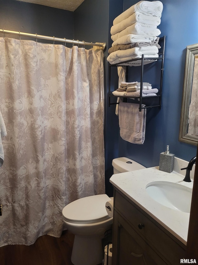 bathroom with wood-type flooring, vanity, and toilet