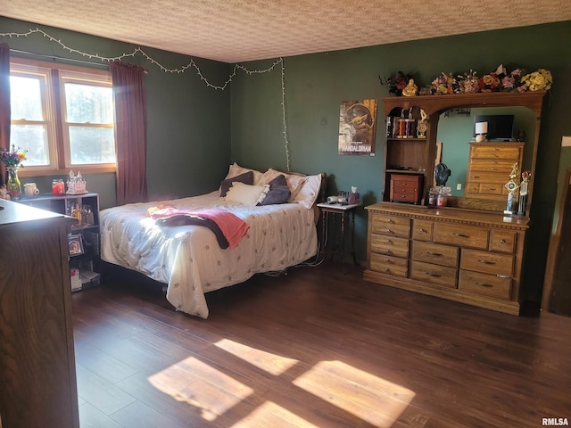 bedroom with dark wood-type flooring and a textured ceiling