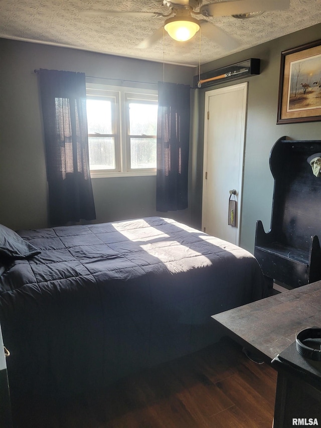 bedroom with hardwood / wood-style floors and a textured ceiling