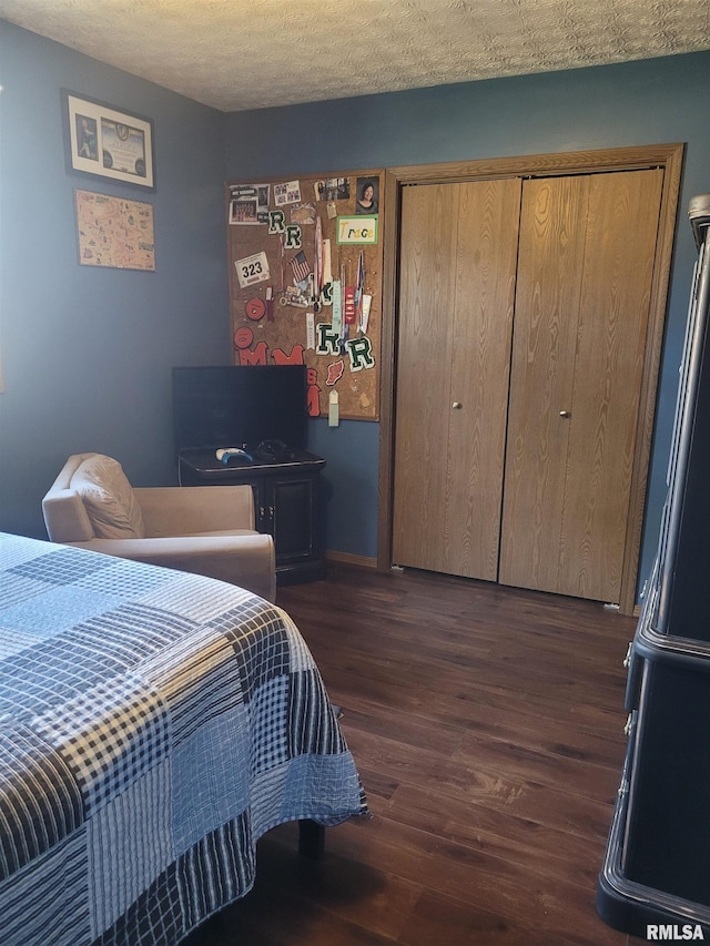 bedroom featuring dark hardwood / wood-style flooring, a closet, and a textured ceiling