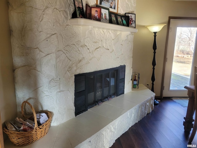 interior details with a stone fireplace and hardwood / wood-style floors