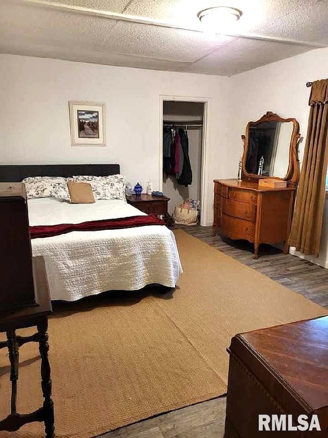 bedroom with wood-type flooring, a closet, and a textured ceiling