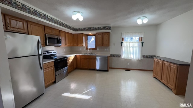 kitchen with sink, stainless steel appliances, and a textured ceiling