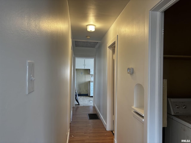 corridor featuring dark hardwood / wood-style flooring and washer / dryer