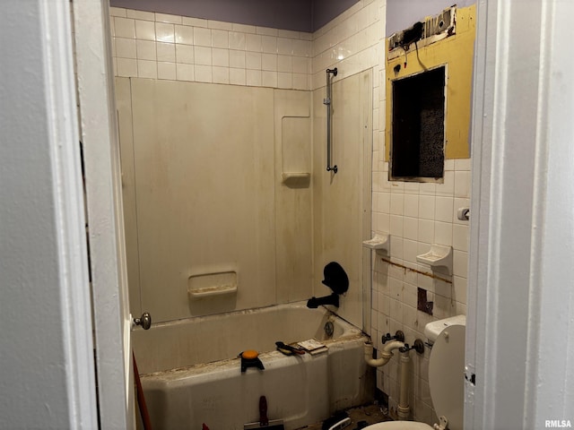 bathroom featuring shower / washtub combination, toilet, and tile walls