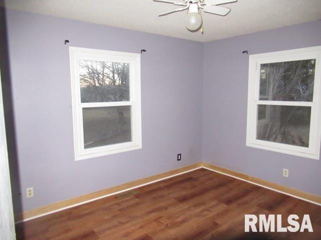 unfurnished room with dark wood-type flooring and ceiling fan