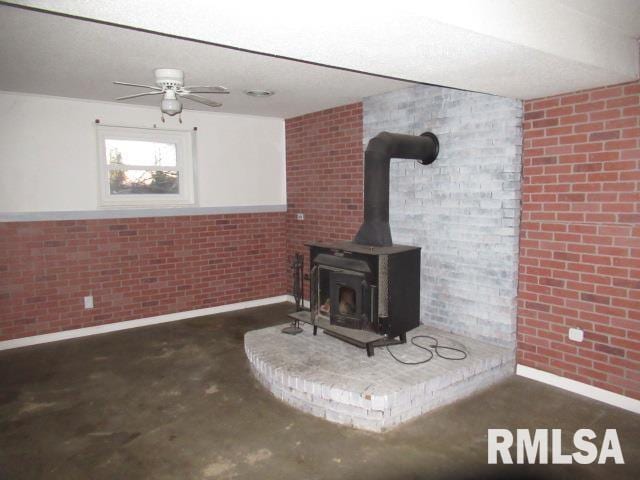 details with concrete floors, ceiling fan, and a wood stove