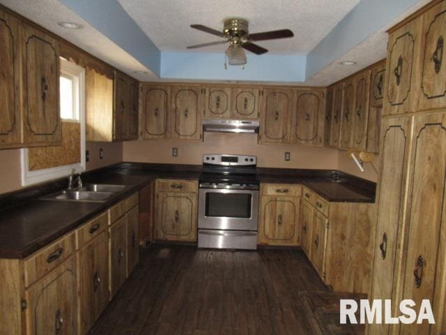 kitchen featuring dark hardwood / wood-style floors, sink, electric range, ceiling fan, and a raised ceiling