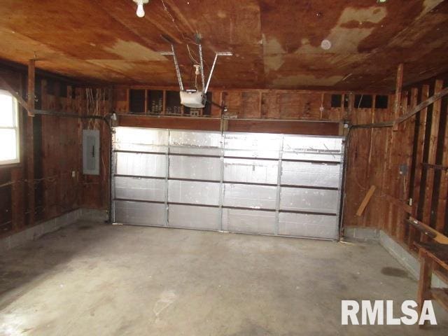 garage with a garage door opener and electric panel