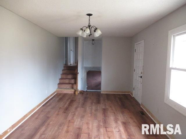 unfurnished room with dark hardwood / wood-style flooring and a notable chandelier