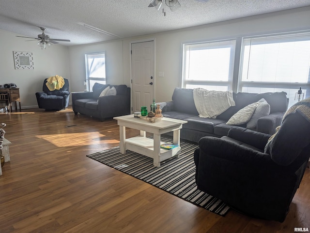 living room featuring dark hardwood / wood-style flooring, a textured ceiling, and ceiling fan