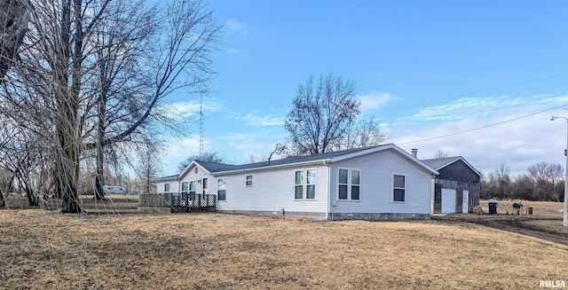 view of property exterior with a wooden deck, a garage, and a lawn