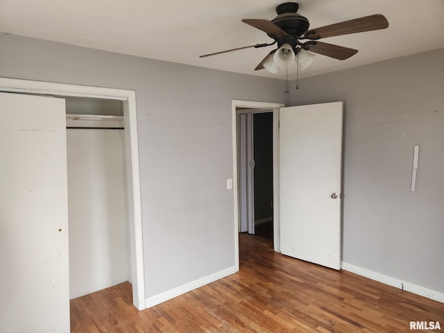 unfurnished bedroom featuring wood-type flooring, ceiling fan, and a closet