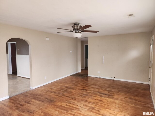 empty room featuring ceiling fan, dark hardwood / wood-style floors, a wall mounted AC, and sink