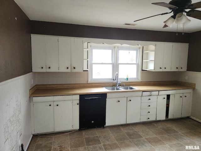 kitchen featuring black dishwasher, sink, decorative backsplash, and white cabinets