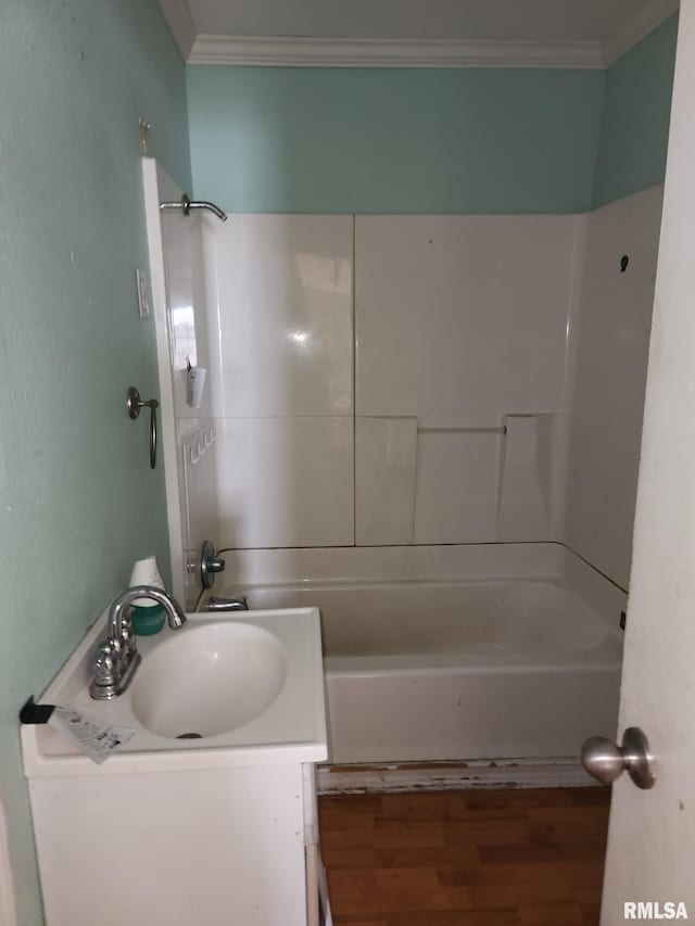 bathroom featuring crown molding, sink, hardwood / wood-style floors, and shower / bathtub combination