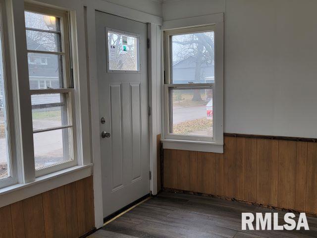 entryway featuring dark hardwood / wood-style floors and wooden walls