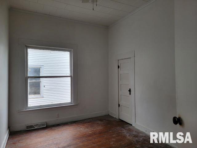 unfurnished room with ornamental molding and dark hardwood / wood-style floors