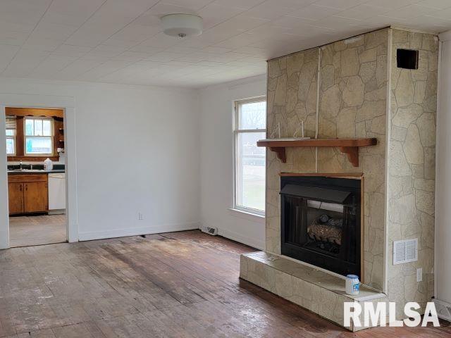 unfurnished living room featuring a large fireplace and light wood-type flooring