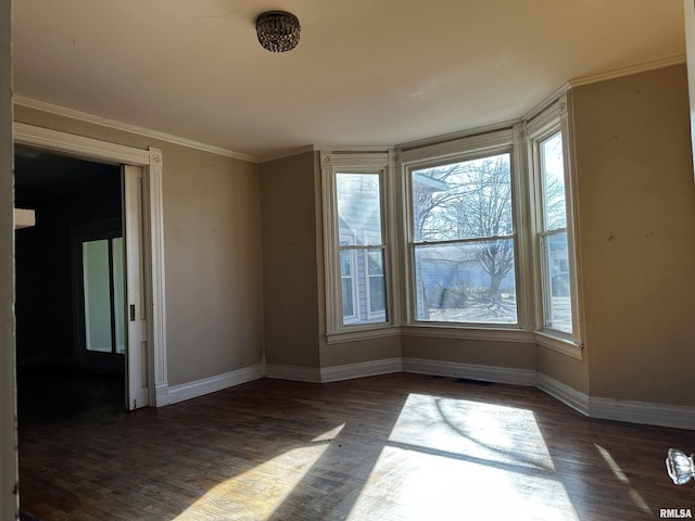 empty room featuring crown molding and dark hardwood / wood-style floors