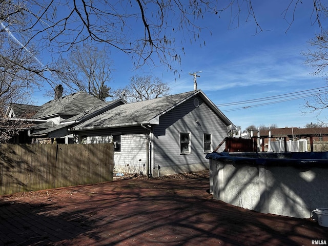 view of side of home with a covered pool