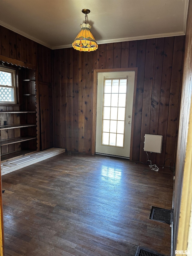 spare room with crown molding, wooden walls, and dark hardwood / wood-style floors