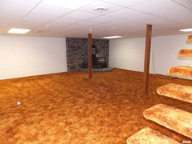 1723 Walnut Hill Rd, Centralia, IL 62801 - finished below grade area featuring a wood stove, carpet flooring, a paneled ceiling, and brick wall