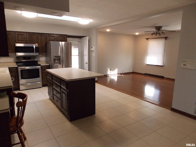 1723 Walnut Hill Rd, Centralia, IL 62801 - kitchen with stainless steel appliances, a ceiling fan, light countertops, dark brown cabinetry, and a kitchen island