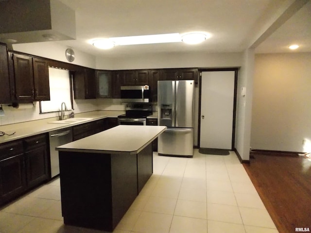 1723 Walnut Hill Rd, Centralia, IL 62801 - kitchen with appliances with stainless steel finishes, light countertops, light tile patterned floors, and a kitchen island