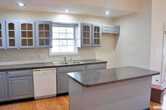 kitchen featuring gray cabinets, dishwasher, sink, and light hardwood / wood-style flooring