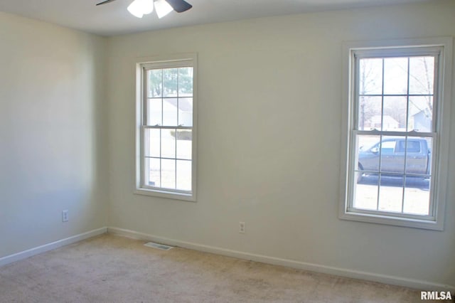 carpeted spare room with ceiling fan