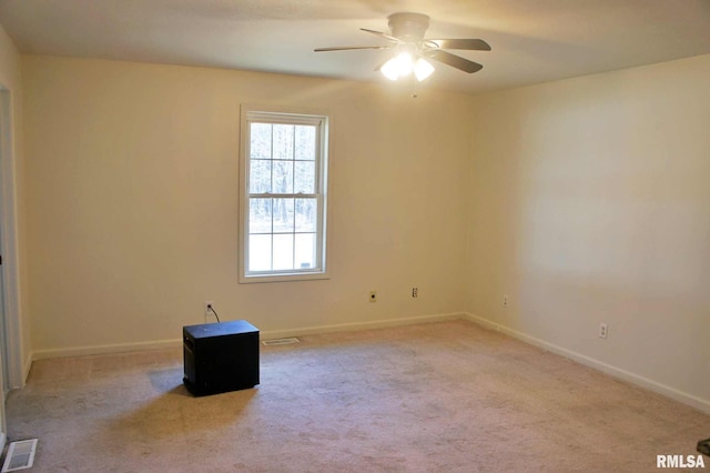 carpeted spare room with ceiling fan