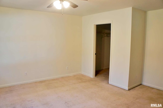 interior space featuring ceiling fan, light colored carpet, a closet, and a walk in closet