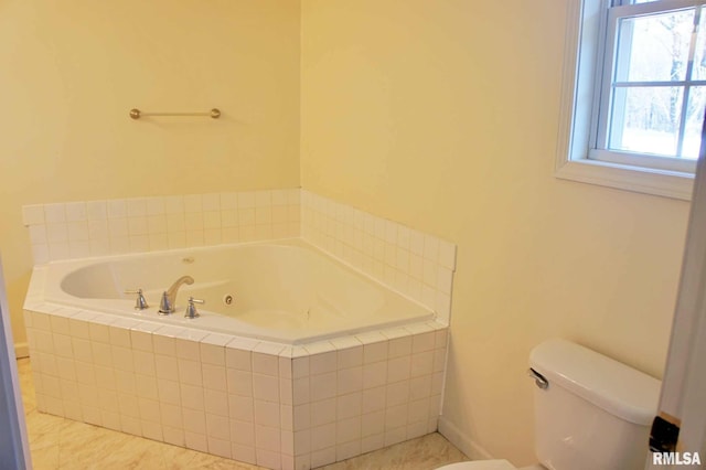 bathroom with tiled tub and toilet