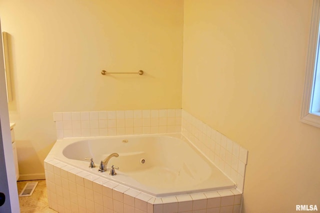 bathroom featuring tile patterned flooring and tiled bath