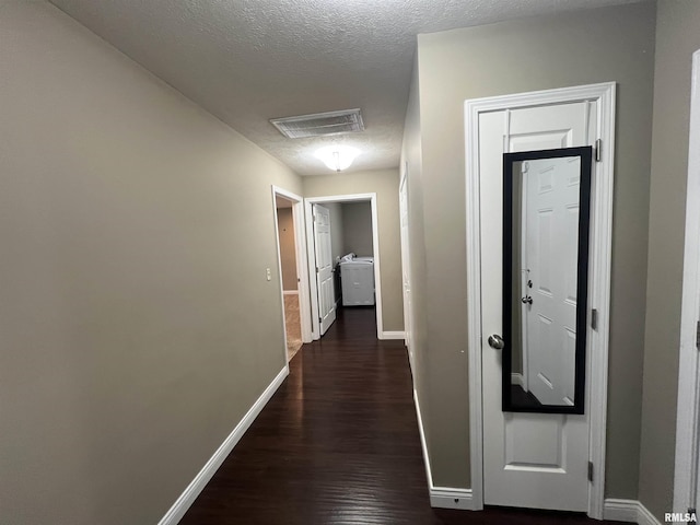 hallway with dark wood-type flooring and a textured ceiling