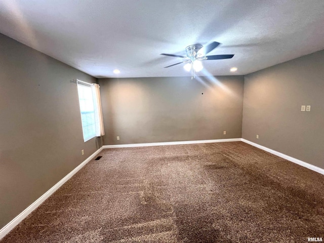 carpeted spare room with a textured ceiling and ceiling fan