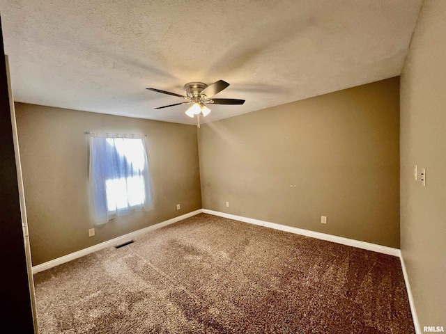 empty room with ceiling fan, carpet floors, and a textured ceiling