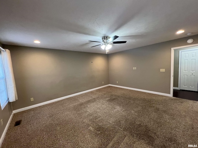 unfurnished room featuring ceiling fan and dark colored carpet