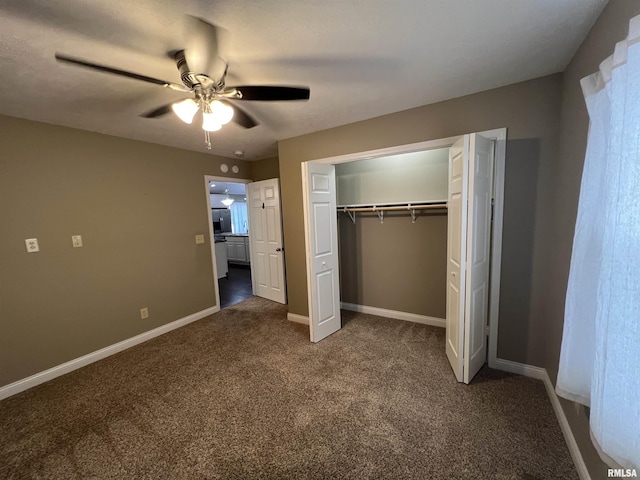 unfurnished bedroom with ceiling fan, dark carpet, and a closet