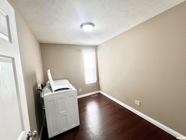 laundry room featuring dark hardwood / wood-style floors, washing machine and clothes dryer, and a textured ceiling