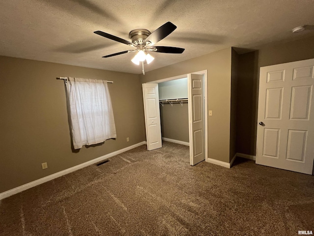 unfurnished bedroom featuring ceiling fan, dark carpet, a closet, and a textured ceiling